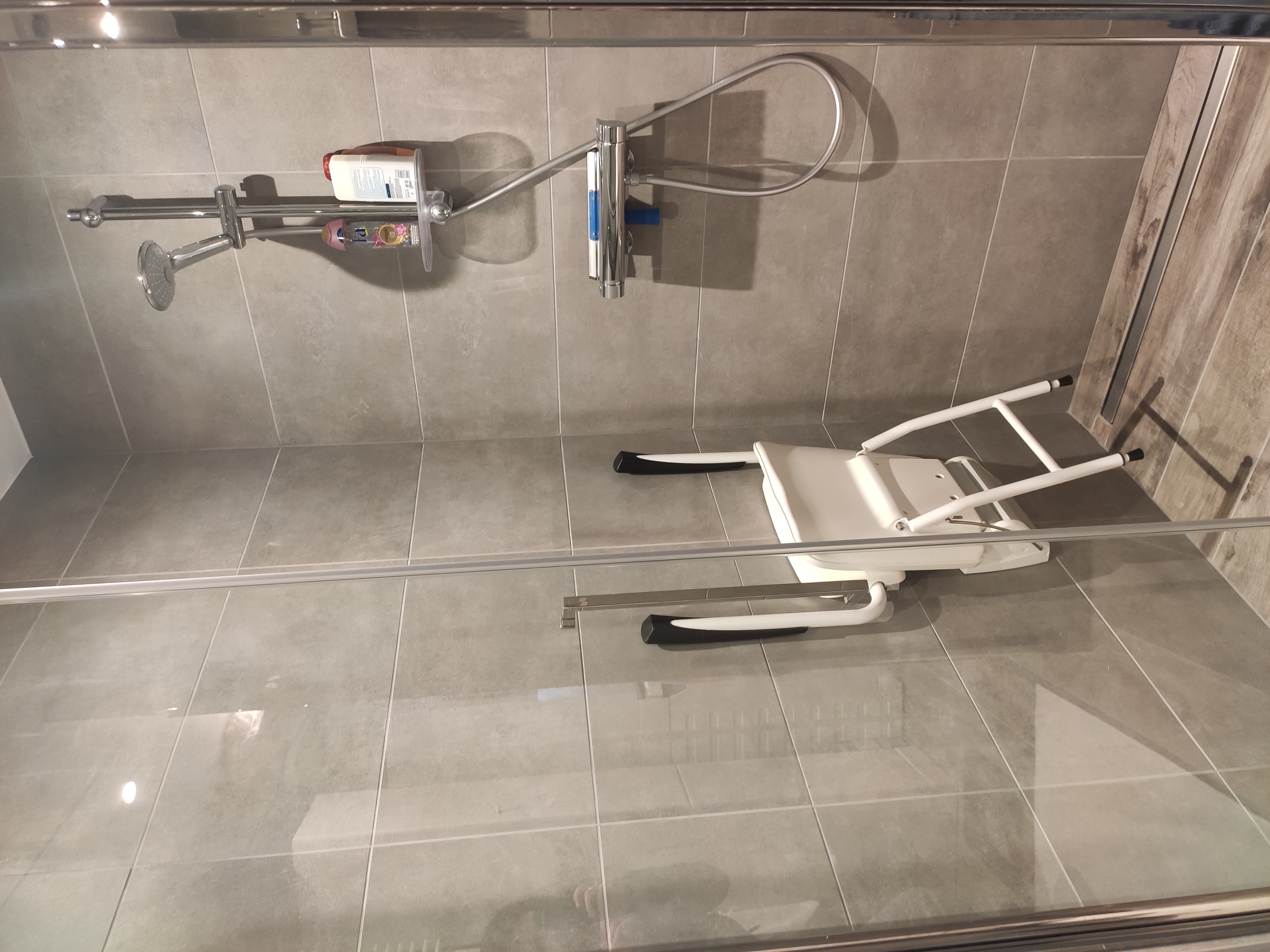 Een aangepaste douche met douchestoeltje voor rolstoelgebruikers.
